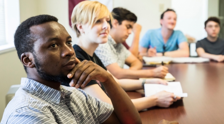 students sitting at a table in an Interdisciplinary Studies class